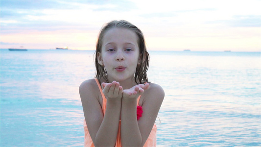可爱的小女孩在海滩有很多在日落时的乐趣快乐的孩子看着视频