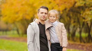 爸爸抱着可爱小女孩享受秋天的公园12秒视频