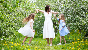 在美丽的春日盛开的樱桃园里的年轻母亲和可爱小女孩11秒视频