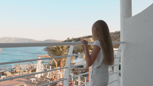 可爱的少女站在阳台上看海景12秒视频