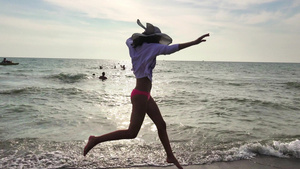 年轻女孩在日落时在海边奔跑22秒视频