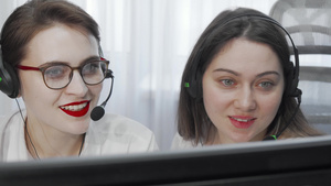 两名女性呼叫中心操作员使用电脑耳机的短片7秒视频