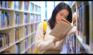 4k背书包的女学生趴在书架上看书21秒视频