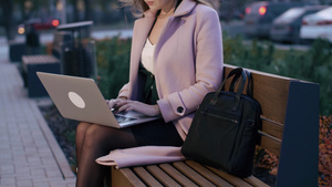 在市广场板凳上从事笔记本电脑工作的青年商业妇女21秒视频