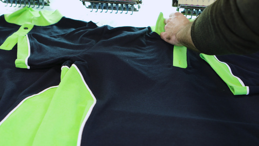 男人在纺织厂检查T恤上的缝纫视频