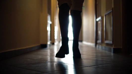 与穿靴子的女子双腿小影带平滑慢动作在走廊走廊上跑动视频