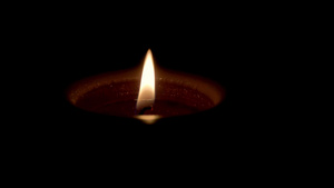 蜡烛在黑暗背景上燃烧悲伤和死亡的概念11秒视频
