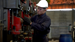专业的亚洲男工在仓库工厂站立并维护大型机器概念工程师34秒视频