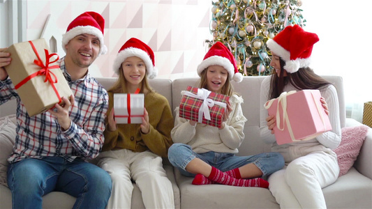 带着孩子带圣诞礼物的年轻快乐家庭视频