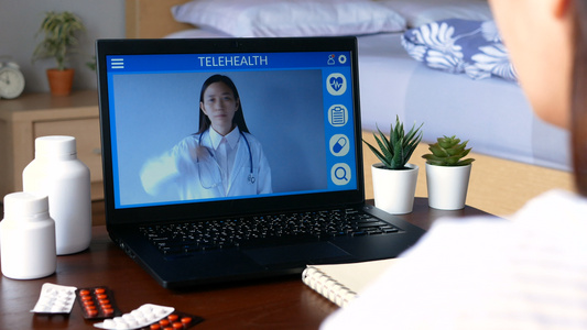 聋哑患者使用远程视频会议通过手语与笔记本电脑上的医生视频