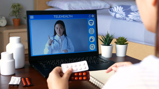 聋哑患者使用远程视频会议通过手语与笔记本电脑上的医生视频