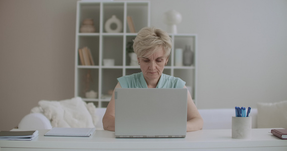 中年妇女在家里使用笔记本电脑视频