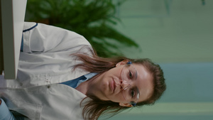 在线视频通话中身穿白大褂的植物学家女性聆听【竖版】29秒视频