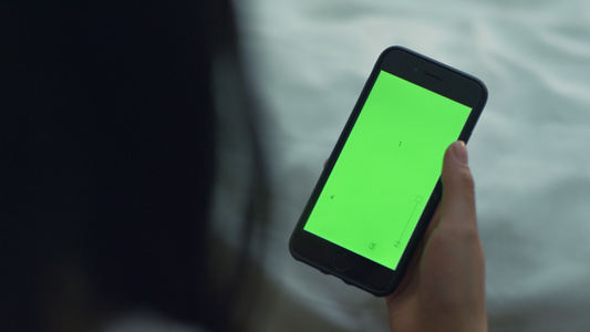 妇女用绿色屏幕触摸智能手机视频