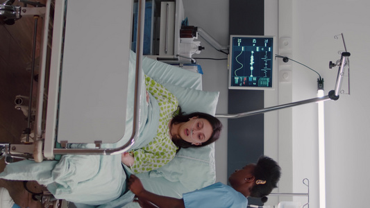 垂直视频美籍护士在医疗康复期间安排患病妇女的床位视频