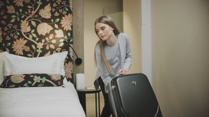 漂亮女商务人士把手提箱放在旅馆的床上30秒视频