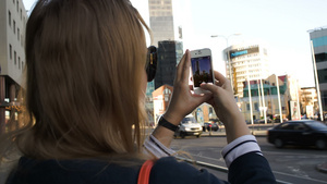 城市里的女人用她的智能手机拍照片12秒视频