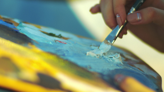 女性手持油漆笔女性在艺术家调色板上混合油画视频