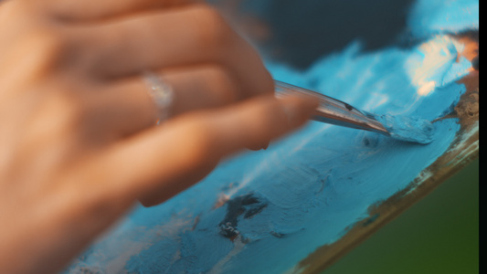 女性画家将调色板上的油漆与刷混合手工绘画技巧视频