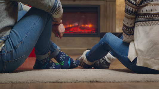 在壁炉前穿着暖袜子的年轻夫妇视频