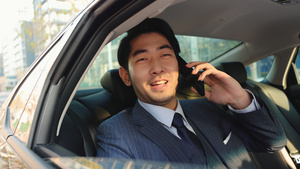 商务男青年坐在汽车后排讲电话42秒视频