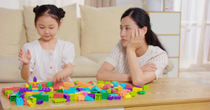 8K妈妈无聊的看着女儿玩积木22秒视频