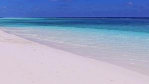 在阳光下的白色沙滩旁的蓝色清澈海洋12秒视频