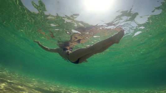 穿着比基尼的性感女性躺在海水表面被夏日阳光水下风景视频