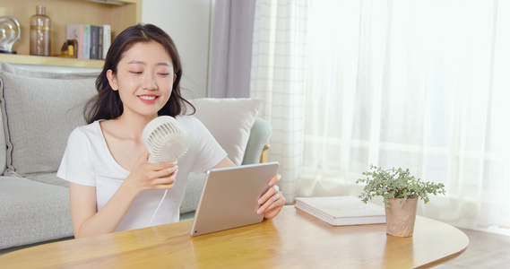 女孩拿起小风扇吹风视频