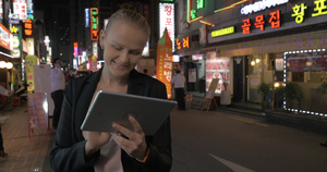 女人晚上在街道上用平板电脑32秒视频