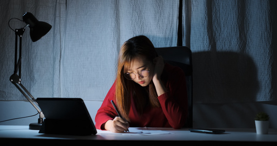 亚洲女性在深夜在家办公室使用平板电脑数字小工具工作视频