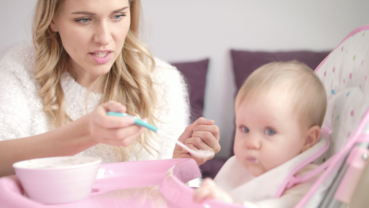 用勺子喂孩的金发女人妈用纯净食物喂婴儿视频