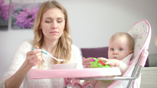 小孩玩具吃从婴儿碗里纯净的食物女人在椅子上喂婴儿视频