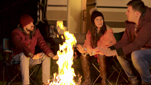 朋友们在寒冷的秋夜在营火旁暖手15秒视频