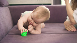 可爱的婴儿爬上紫罗兰的床裸体儿童穿着尿布咬玩具20秒视频