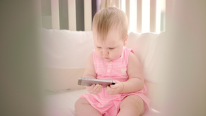婴儿与智能手机玩游戏在上看卡通的小女孩11秒视频