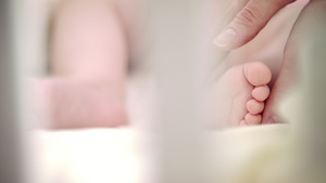母亲手抚摸婴儿脚母亲保护婴儿新生命按摩制服22秒视频