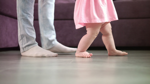 小婴儿脚在父母支助下地板上行走18秒视频