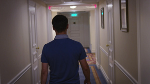 穿着蓝衬衫的年轻人沿走廊在旅馆后视线的走廊上17秒视频