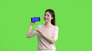 4k女生手拿手机横屏展示绿幕抠像视频9秒视频