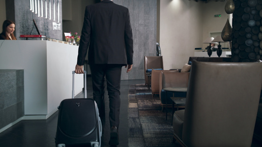 带旅行李箱的商务人士在假日抵达旅馆视频