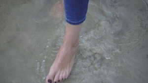 女性赤脚站立在底沙移动海水18秒视频