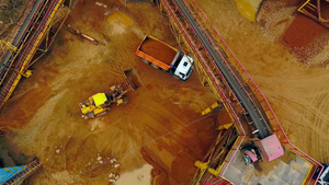 倾卸卡车装沙的挖掘机载器空中观察沙堆工作17秒视频