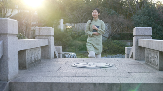 手捧古书走在石桥上的女孩视频