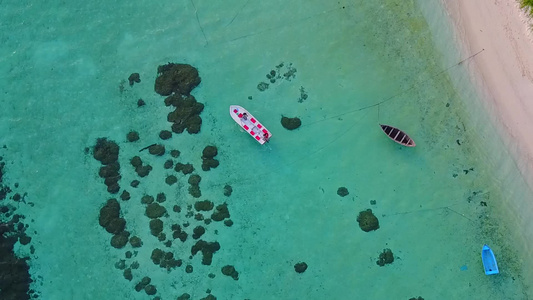 以蓝水和白沙沙背景进行热带海岸海滩度假的无人驾驶飞机视频