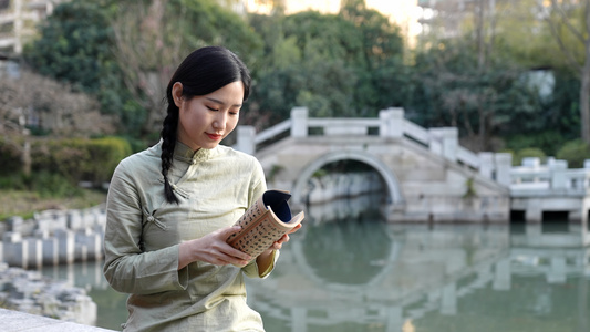 坐在湖边看书的文静女孩视频