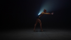 在黑暗的舞蹈室做倒立的运动女人18秒视频