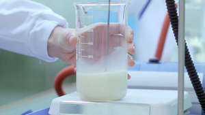 科学家在实验室设备上装有计量杯子和牛奶的实验室设备6秒视频