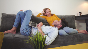 情侣在沙发上相爱笔记本电脑笑着男孩躺在女孩腿上12秒视频