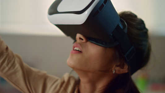 戴着虚拟现实耳机的女孩沉浸在虚拟现实中视频
